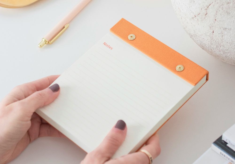 Open daily Planner with a 60-day preconception checklist and a gold pen